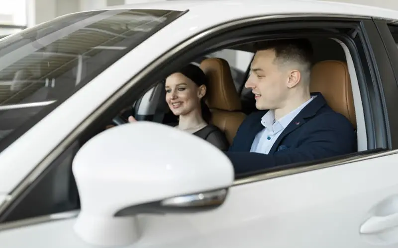 Paar begutachtet ein Fahrzeug vor dem Kauf.